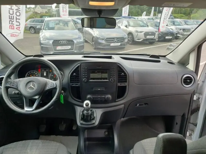 Vue intérieure avant du Mercedes Vito Fourgon blanc, montrant tableau de bord, volant et levier de vitesses manuel.