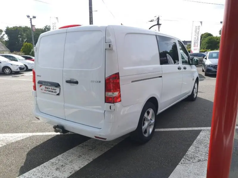 Vue 3/4 arrière droite d'un Mercedes Vito Fourgon blanc Pur Spéciale avec portes arrière battantes et vitres teintées.