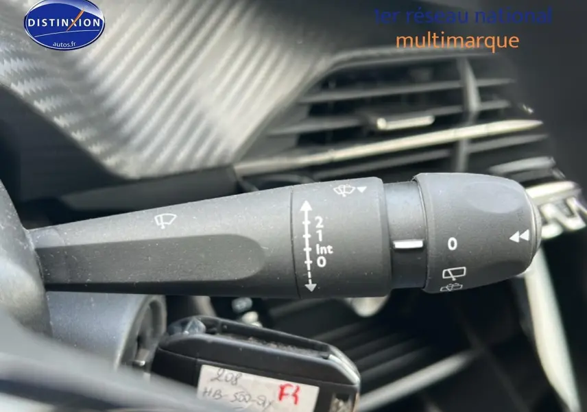 Gros plan sur la commande d'essuie-glace du tableau de bord d'une Peugeot 208 gris artense, version 1.2 100 style.