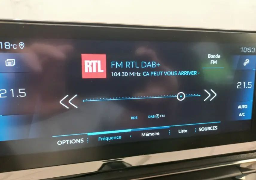 Écran tactile intérieur du Peugeot 5008 affichant la radio FM RTL à 104,3 MHz avec réglage de la climatisation à 21,5°C.