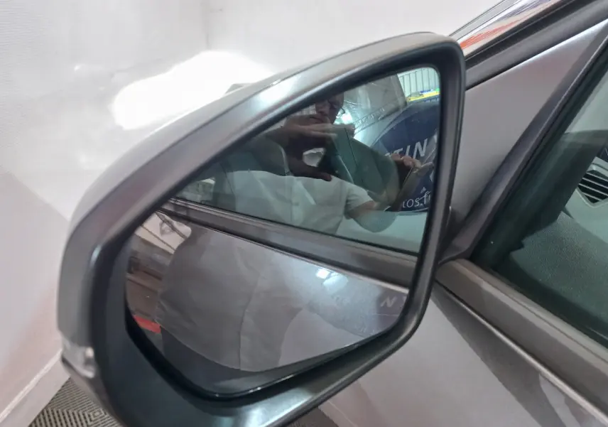 Rétroviseur extérieur côté gauche gris foncé du Peugeot 5008 2021, avec surface miroir et cadre plastique visible.