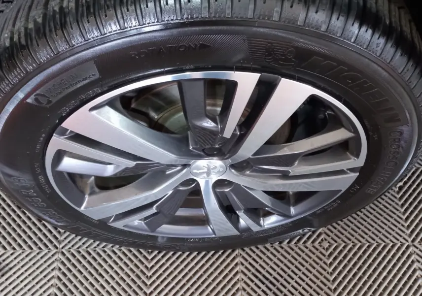 Gros plan sur la jante alliage bicolore et pneu Michelin du Peugeot 5008 gris foncé, vue de dessus.
