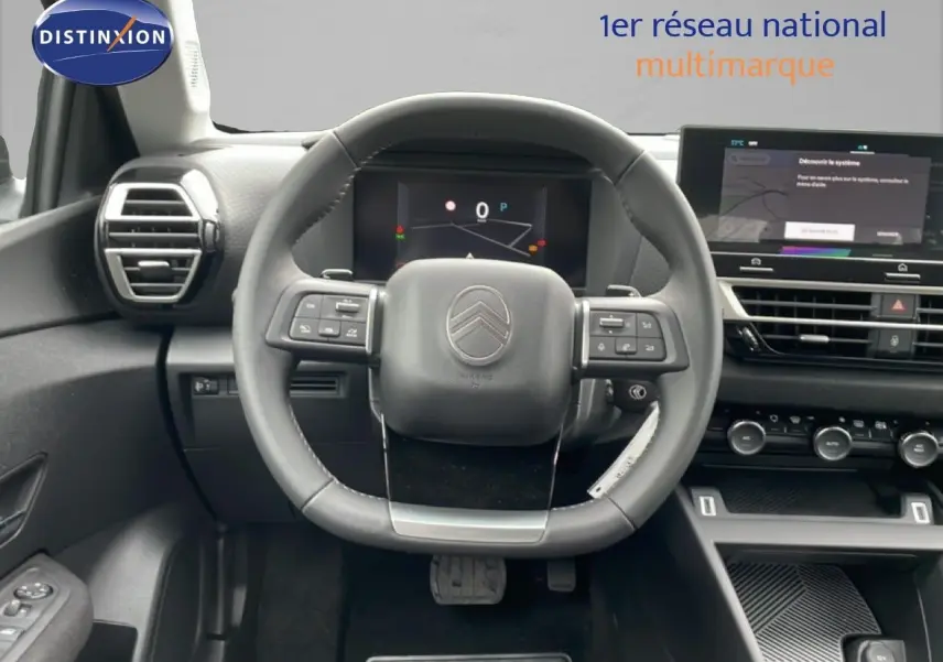 Vue intérieure centrée sur le volant noir du Citroën C4 2026 avec tableau de bord digital et écran tactile.