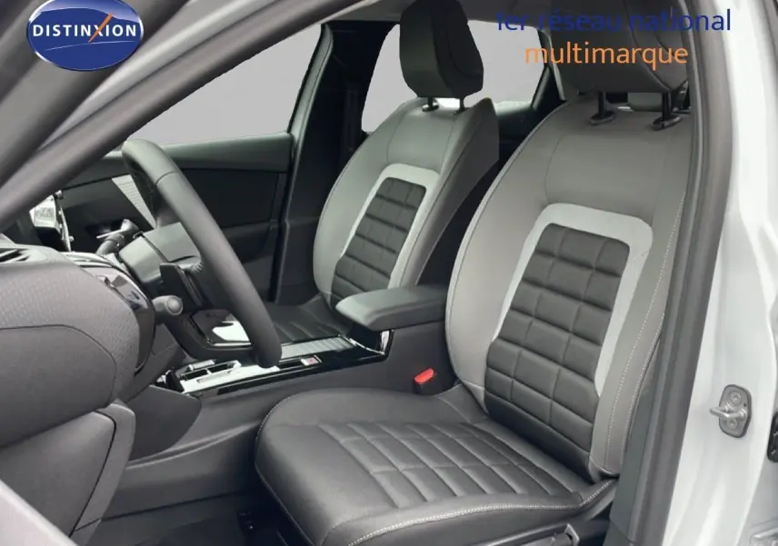 Vue intérieure côté conducteur de la Citroën C4 blanche métal 2026, sièges en cuir et tissu noir et gris.