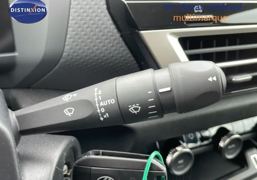 Gros plan sur la commande d’essuie-glace à gauche du volant dans l’habitacle noir du Citroën C4 blanc métal 2026.