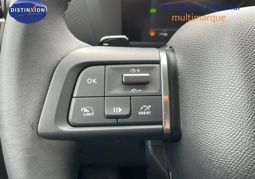 Gros plan sur les commandes de régulateur de vitesse au volant cuir noir d'une Citroën C4 blanche métal 2026.