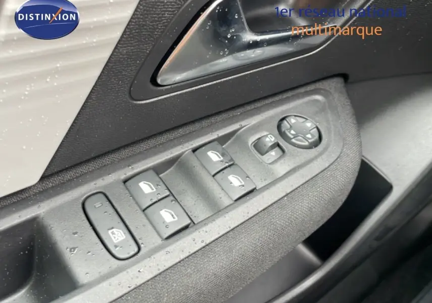 Gros plan sur les commandes des vitres et rétroviseurs côté conducteur d'une Citroën C4 blanche métal 2026.