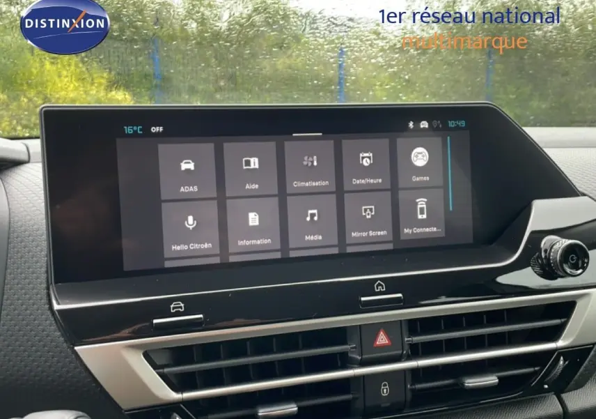 Écran tactile central affichant les options multimédia et climatisation dans le tableau de bord d'une Citroën C4 blanche.