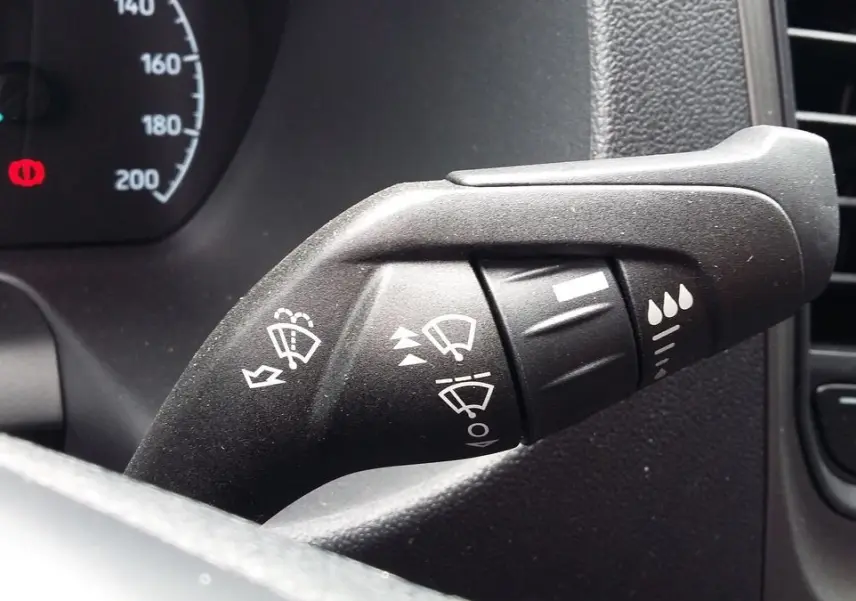 Gros plan sur la commande d’essuie-glace du tableau de bord du Ford Transit Fourgon blanc Glacier 2022.