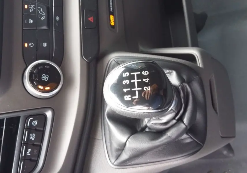 Le levier de vitesses manuel noir du Ford Transit Fourgon T350 blanc, avec console centrale et commandes visibles.