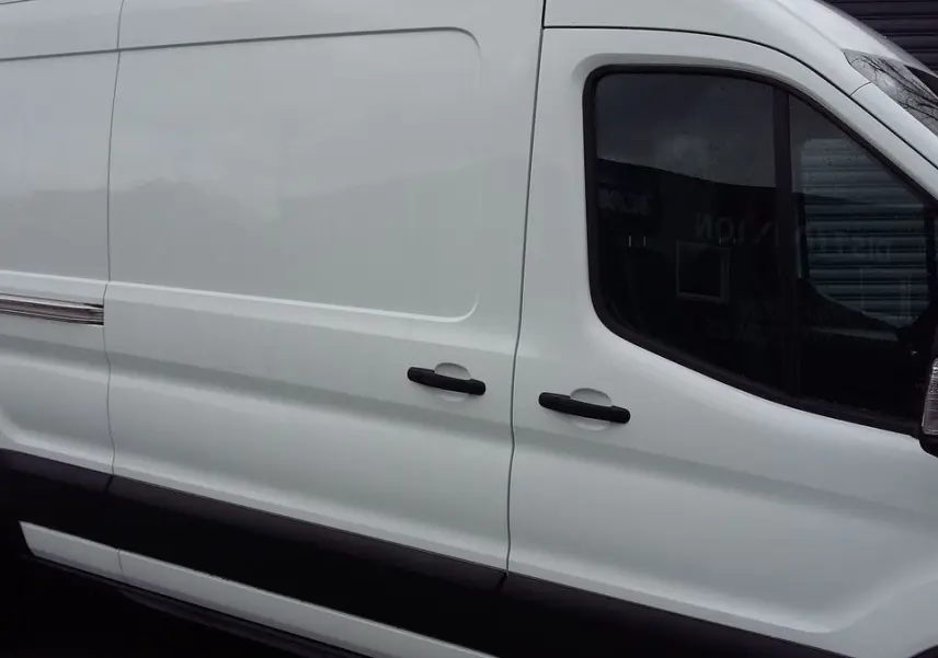Vue latérale droite d'un Ford Transit Fourgon blanc glacier, mettant en valeur ses portes coulissantes et poignées noires.