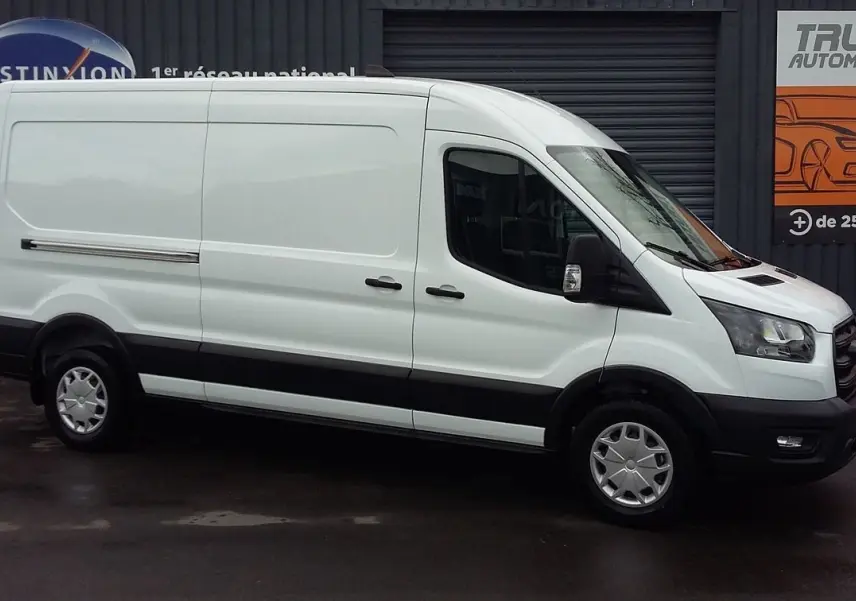 Fourgon Ford Transit blanc glacier vu de profil côté droit, avec pare-chocs noirs et jantes argentées.