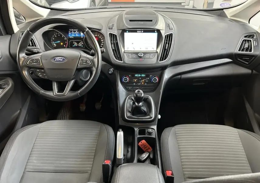 Vue intérieure du tableau de bord et console centrale d'une Ford C-MAX 2018 avec volant multifonction et boîte manuelle.