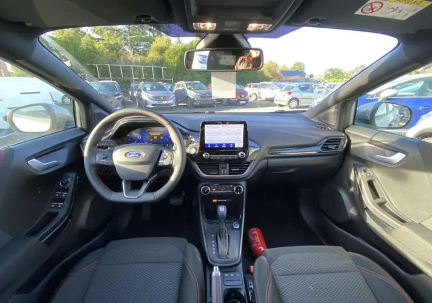Intérieur du Ford Puma 2021 gris, vue frontale du tableau de bord avec volant multifonctions et écran tactile central.