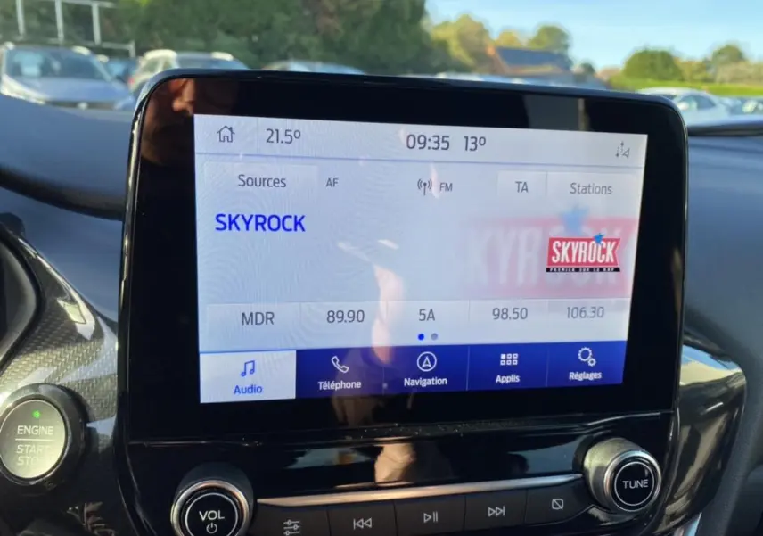 Écran tactile central du Ford Puma 2021 affichant la radio Skyrock avec commandes audio et bouton start/stop à gauche.