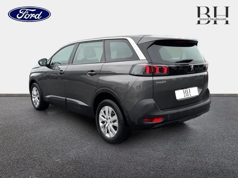Peugeot 5008 gris Platinium vue 3/4 arrière droit, avec feux arrière LED et jantes alu visibles.