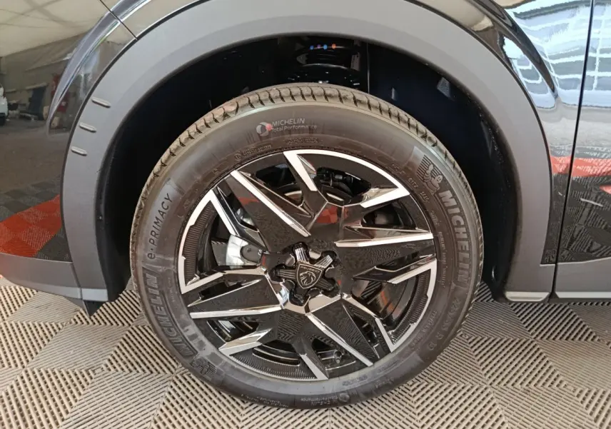Gros plan sur la roue avant gauche noire du Peugeot 3008 1.2 Hybrid 145 GT avec jante alliage bicolore et pneu Michelin.
