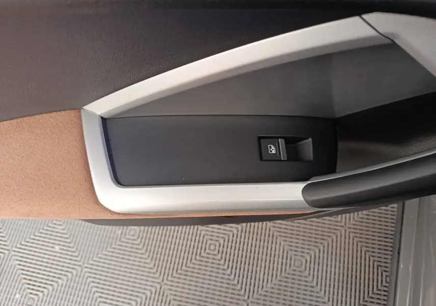 Détail de la commande de verrouillage de porte sur la garniture intérieure beige et noire d'un Audi Q3 Sportback 2024.