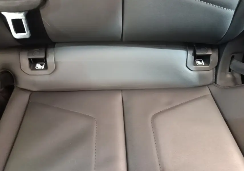 Gros plan sur la banquette arrière en cuir noir de l'Audi Q3 Sportback 45 TFSI e, avec attaches Isofix visibles.