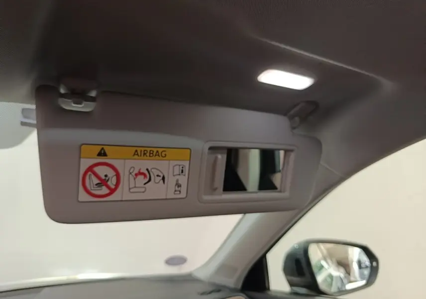 Détail intérieur du pare-soleil gris avec miroir et avertissement airbag, côté conducteur de l'Audi Q3 Sportback 2024.