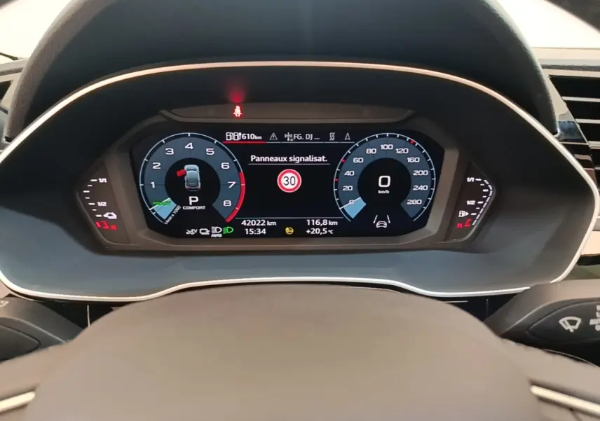 Vue rapprochée du combiné d'instruments numérique de l'Audi Q3 Sportback 45 TFSI e, affichant la vitesse et alertes.
