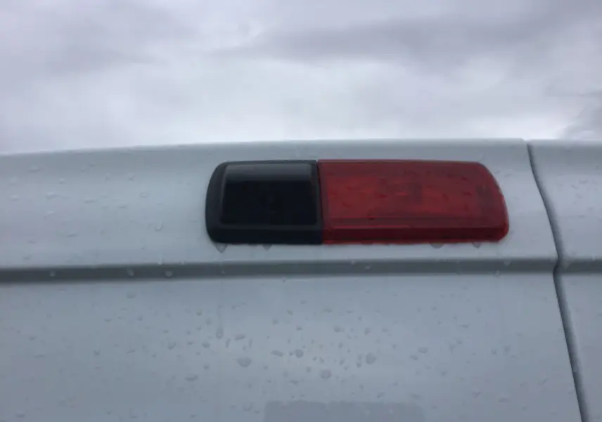 Gros plan sur la caméra de recul intégrée à la porte arrière blanche du Renault Trafic Fourgon 2023.