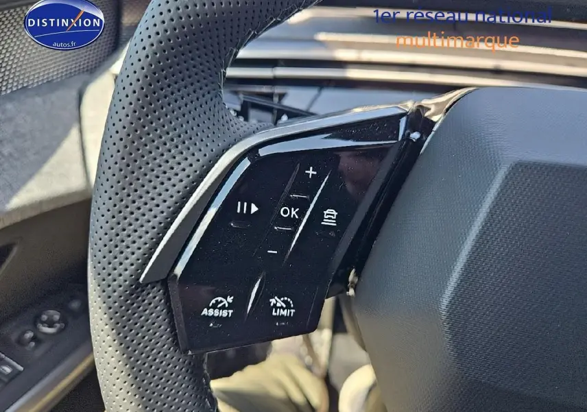 Gros plan sur les commandes multifonctions du volant cuir perforé côté gauche d’un Peugeot 3008 noir perla nera 2025.