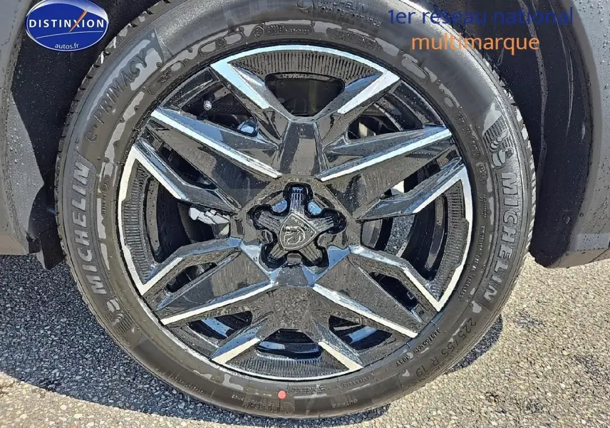 Gros plan sur la jante alu noire et brillante du côté avant droit du Peugeot 3008 noir Perla Nera 2025.