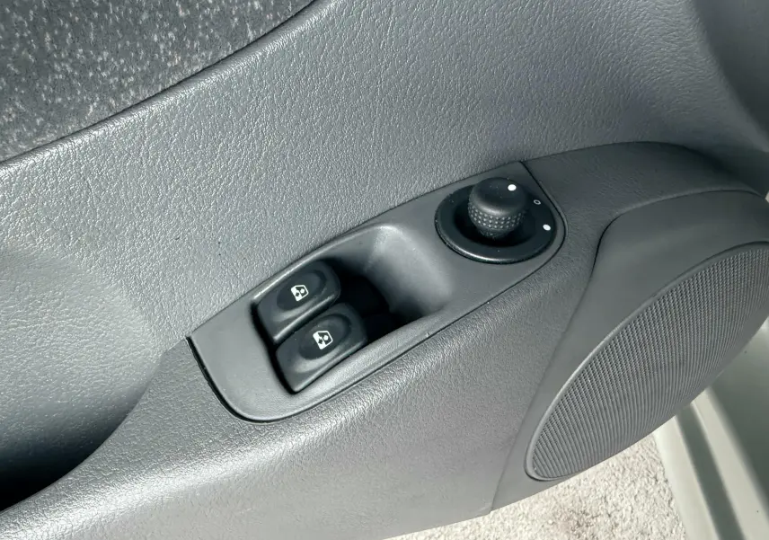Détail des commandes de lève-vitres et réglage des rétroviseurs sur la porte côté conducteur d’une Renault Mégane 1.6 i 110ch BVA.