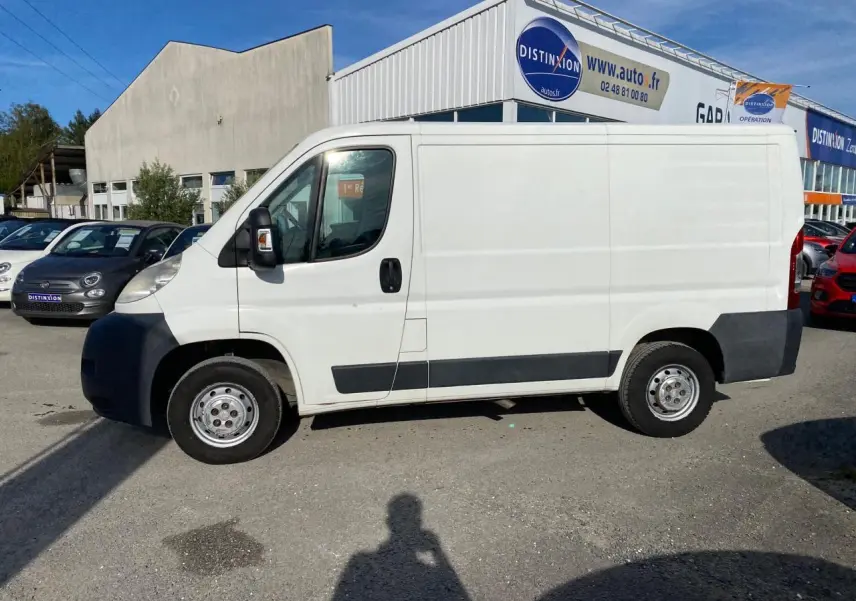 Vue de profil côté gauche d'un fourgon blanc Citroën Jumper 2013 avec attelage, stationné en extérieur.