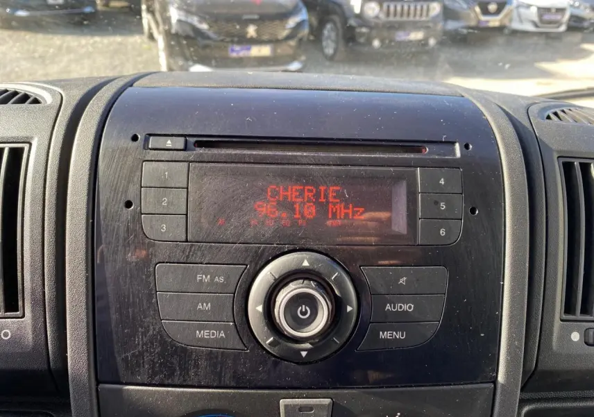 Vue rapprochée du tableau de bord noir du Citroën Jumper blanc 2013, affichant la radio sur 96.10 MHz avec station Chérie FM.