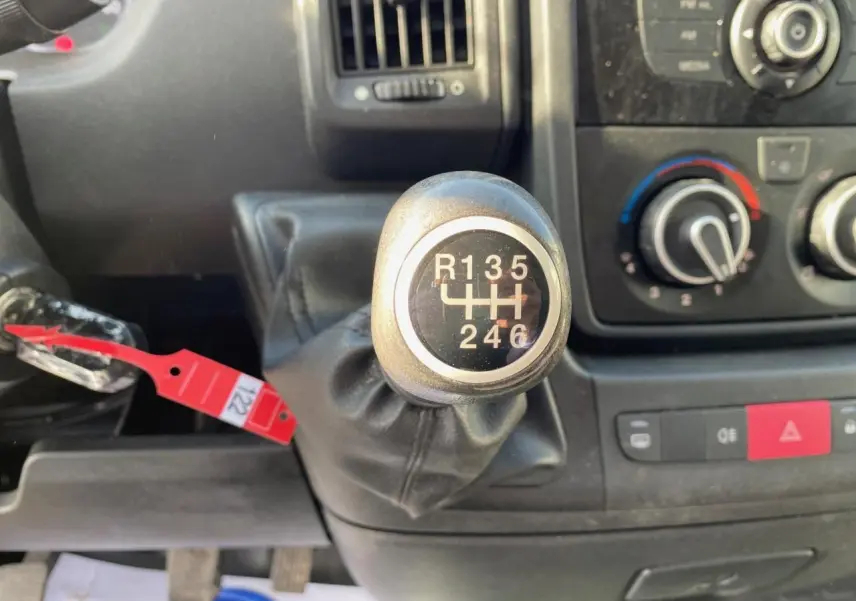 Le levier de vitesses manuel en gros plan dans l'habitacle d'un Citroën Jumper blanc, avec tableau de bord et commandes visibles.