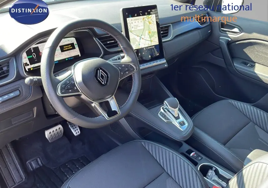 Intérieur avant du Renault Captur E-Tech hybride 2025, avec tableau de bord numérique et sellerie noire élégante.