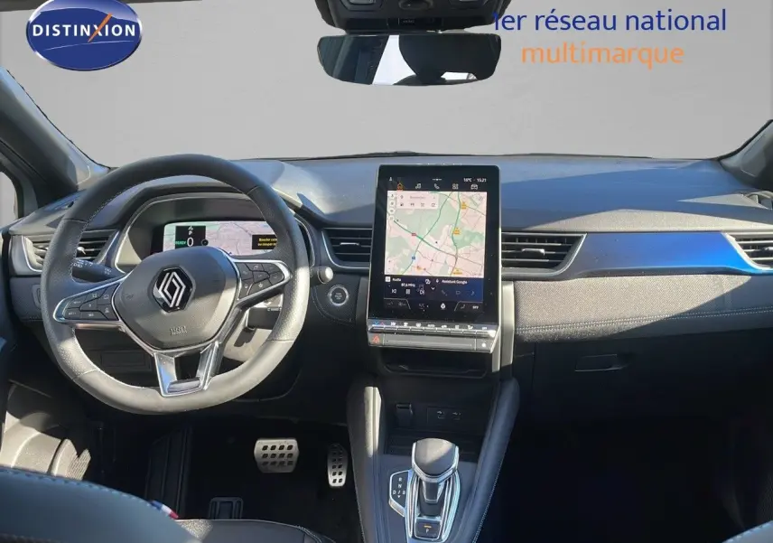 Vue intérieure du tableau de bord du Renault Captur E-Tech hybride, avec écran tactile central et volant multifonction.
