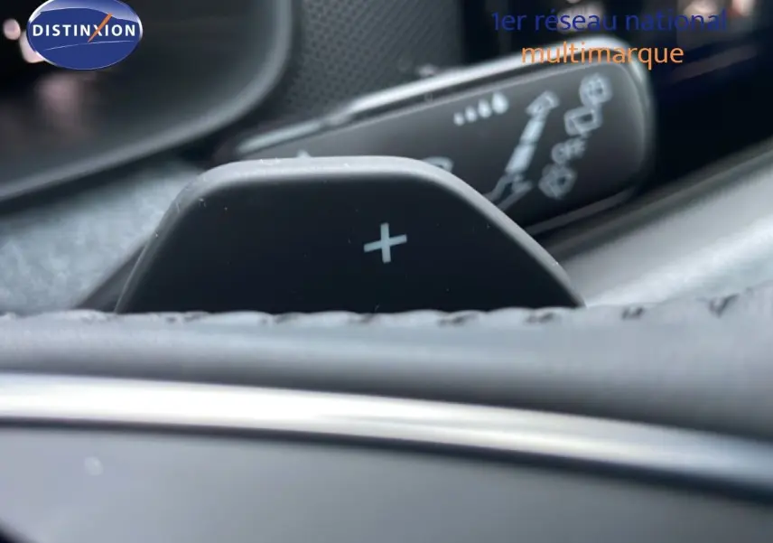 Gros plan sur la palette de changement de vitesse "+" dans l'habitacle d'une Skoda Kamiq gris graphite.