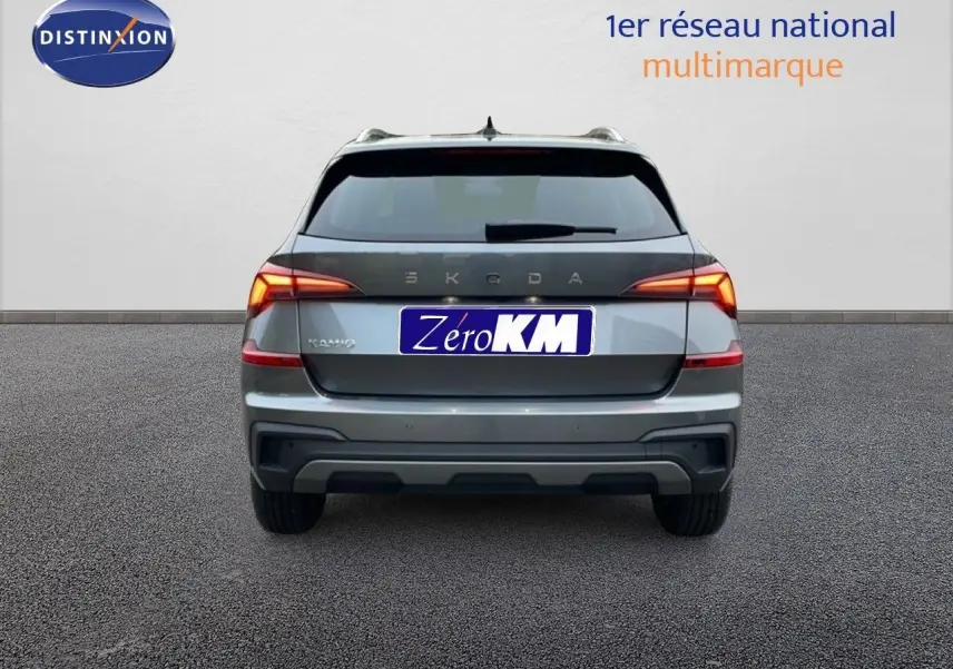 Vue arrière d'un Skoda Kamiq gris graphite métal avec feux allumés sur fond neutre.