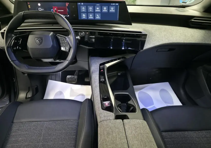 Intérieur avant du Peugeot 5008 2025, vue du conducteur, avec tableau de bord numérique et console centrale tissu gris.