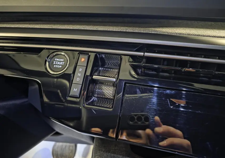 Détail de la console centrale noire laquée du Peugeot 5008 2025, avec bouton start/stop et sélecteur de boîte auto.