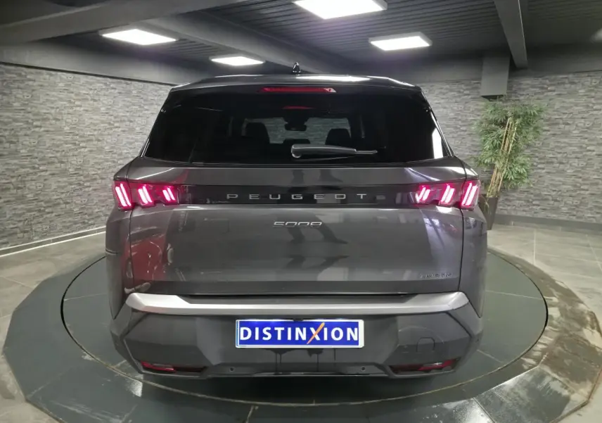 Vue arrière d’un Peugeot 5008 gris métallisé avec feux arrière LED en forme de griffes et bandeau noir laqué.