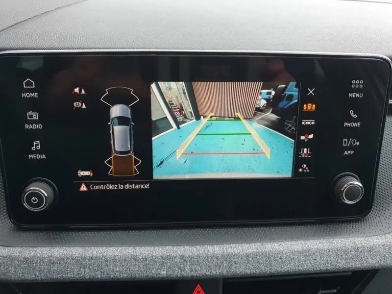 Écran tactile intérieur montrant la caméra de recul du Skoda Kamiq gris diamant, avec lignes de guidage colorées.
