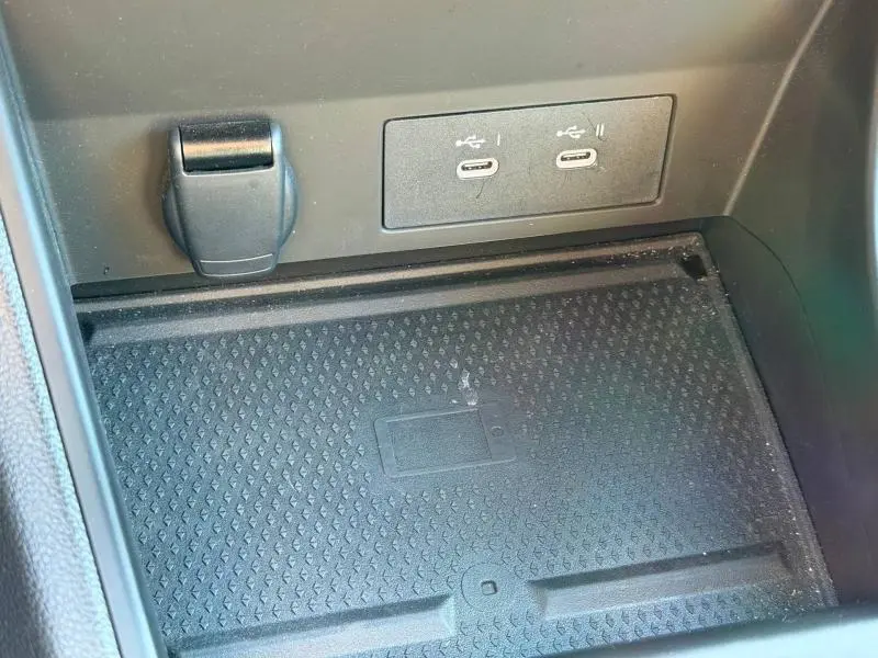 Gros plan sur la zone de recharge sans fil et les deux ports USB-C du Renault Captur 2025 Rouge Flamme.