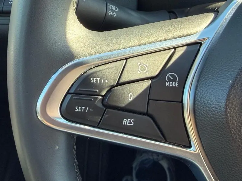 Gros plan sur les commandes noires du volant du Renault Captur 2025, avec boutons de régulateur et contour chromé.