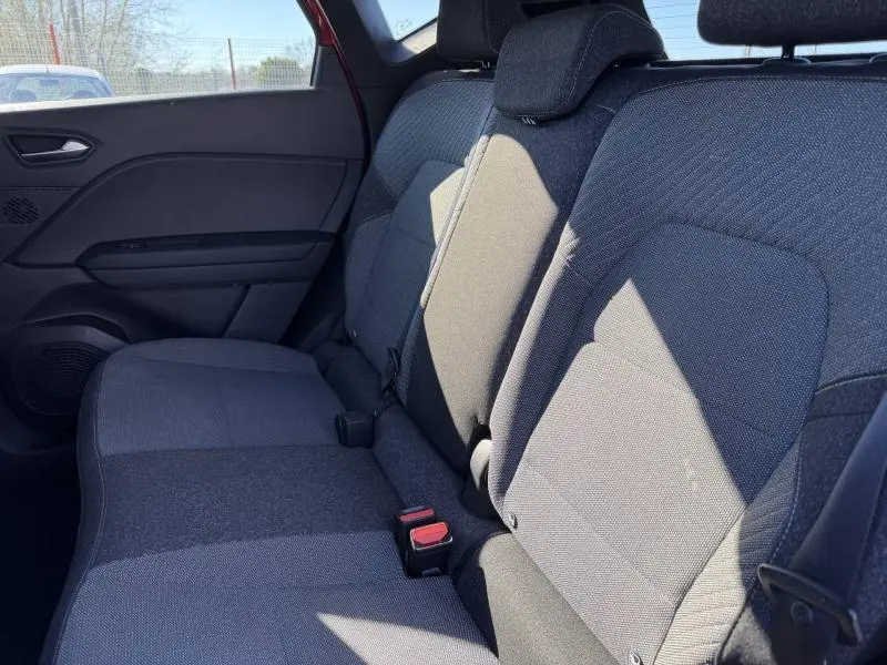 Vue intérieure du siège arrière côté droit du Renault Captur 2025 avec tissu gris et ceinture de sécurité visible.