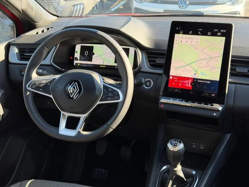 Vue intérieure du tableau de bord du Renault Captur 2025 Rouge Flamme, avec volant multifonction et écran tactile vertical.