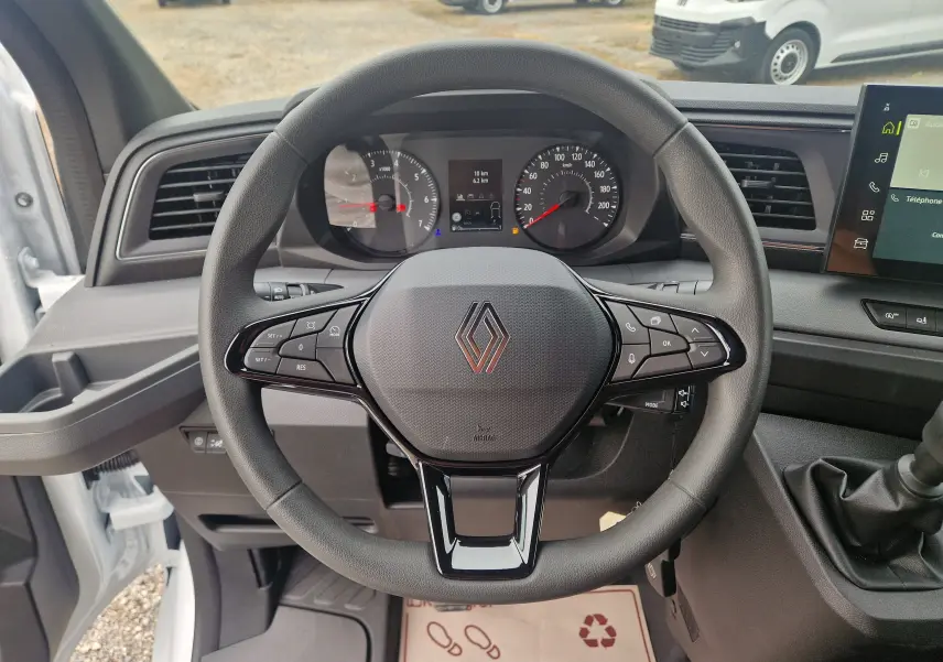 Vue intérieure centrée sur le volant noir du Renault Master blanc 2026 avec tableau de bord et commandes visibles.