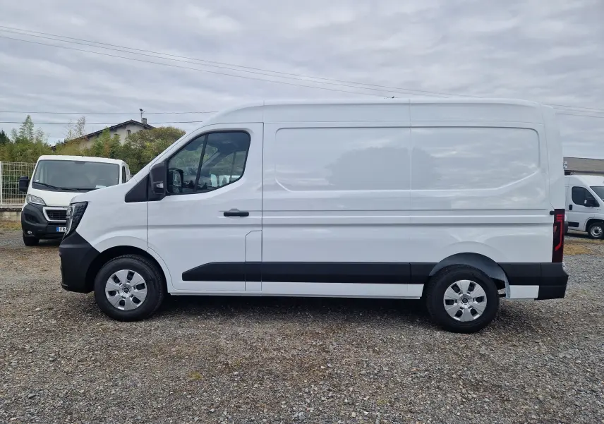 Vue de profil côté gauche d’un utilitaire Renault Master blanc L2H2 avec protections noires et jantes acier.