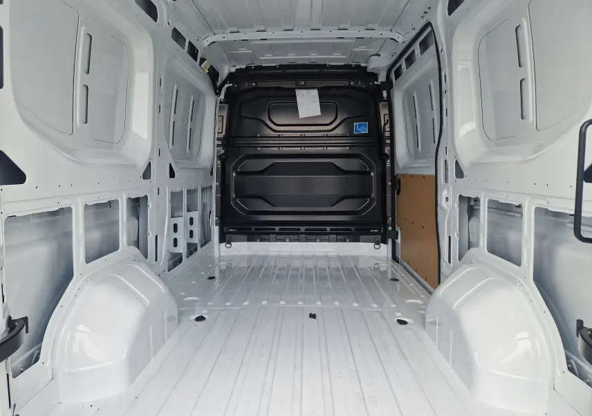 Vue intérieure arrière du Renault Master blanc L2H2 2026, montrant l’espace de chargement vide et la cloison noire séparatrice.