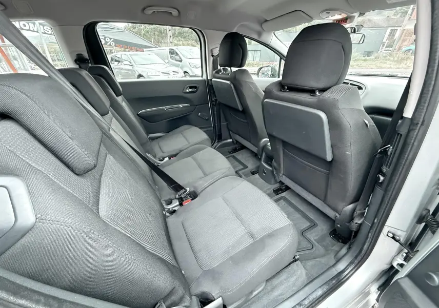 Vue intérieure côté droit montrant les sièges arrière en tissu gris du Peugeot 5008 gris de 2010 avec porte ouverte.