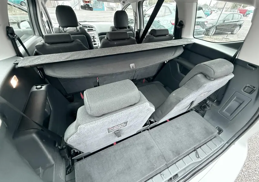 Vue arrière intérieure du Peugeot 5008 gris de 2010, montrant les sièges arrière rabattus et le coffre partiellement visible.