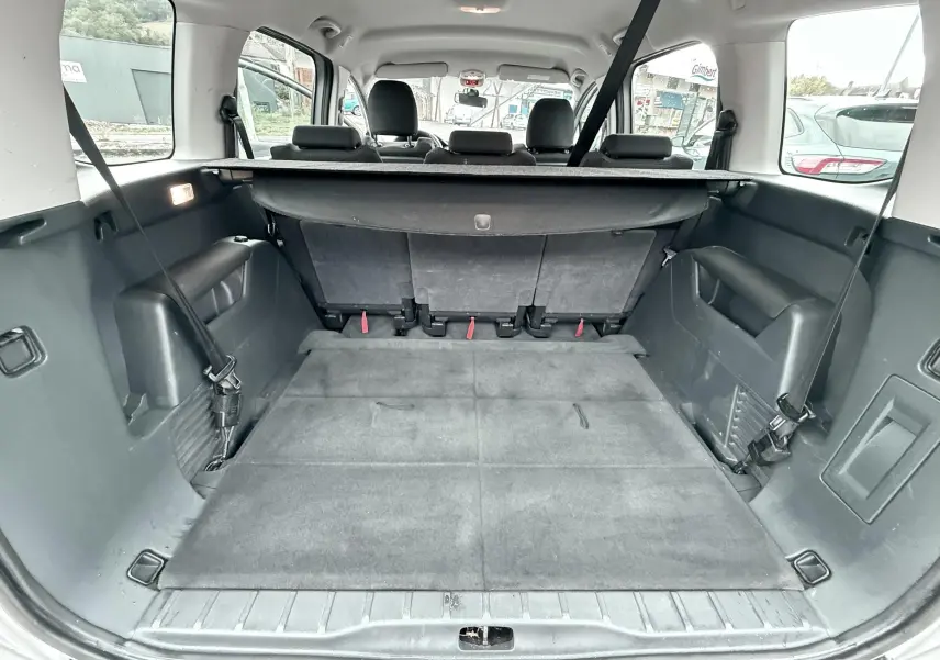 Vue de l’intérieur du coffre spacieux d’un Peugeot 5008 gris avec banquette arrière rabattue et habillage noir.